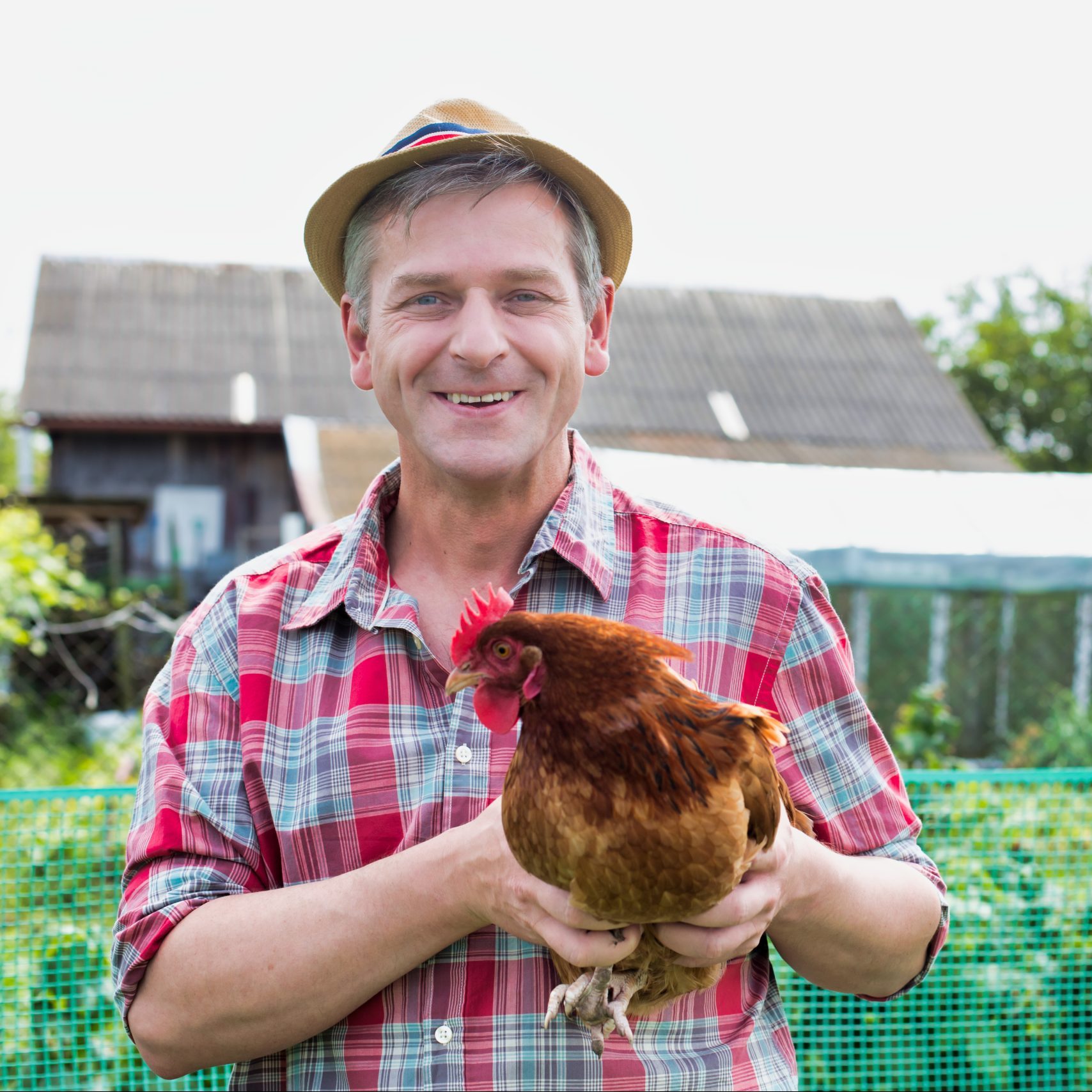 happy farmer in backyard with healthy chicken